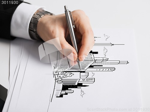 Image of close up of male hand with pen drawing graph