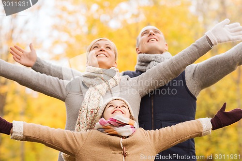 Image of happy family having fun in autumn park