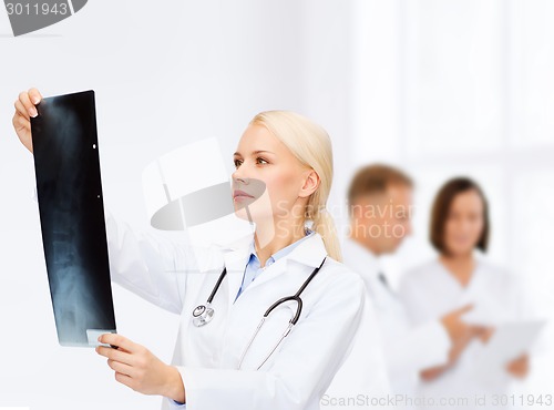 Image of serious female doctor looking at x-ray