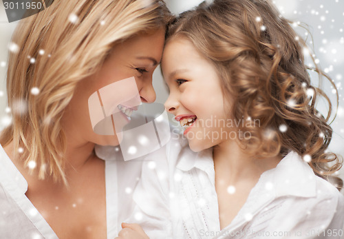 Image of happy mother and daughter cuddling