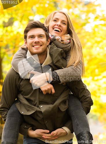 Image of smiling friends having fun in autumn park