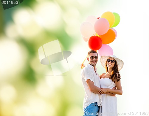 Image of smiling couple with air balloons outdoors