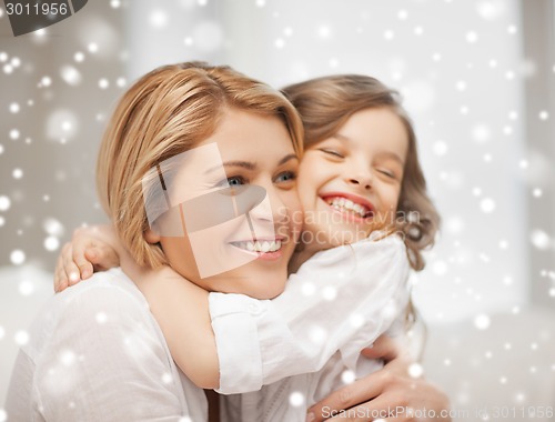 Image of happy mother and daughter hugging at home