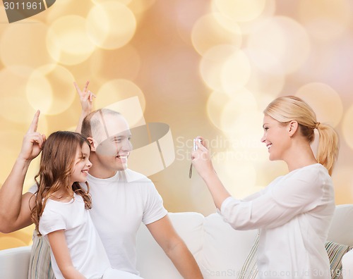 Image of happy family with camera at home