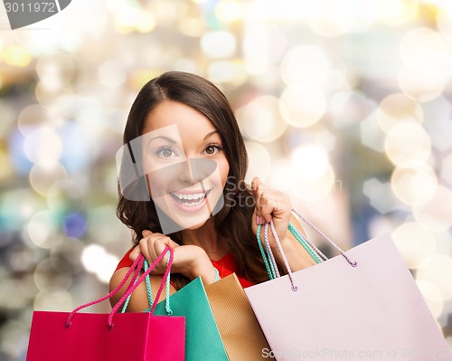 Image of smiling woman with colorful shopping bags