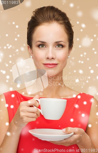 Image of smiling woman in red dress with cup of coffee