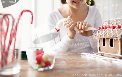 Image of close up of woman making gingerbread houses