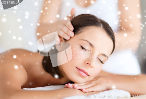 Image of beautiful woman getting face or head massage