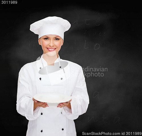 Image of smiling female chef with empty plate