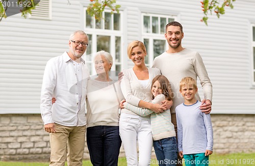 Image of happy family in front of house outdoors