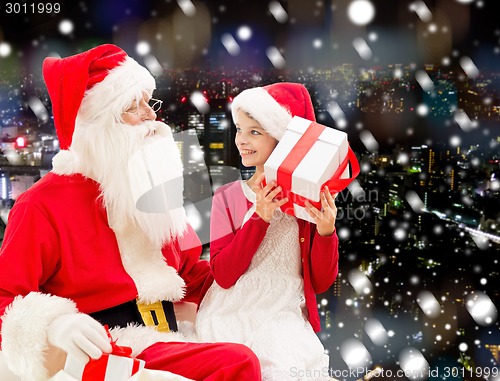 Image of smiling little girl with santa claus and gifts