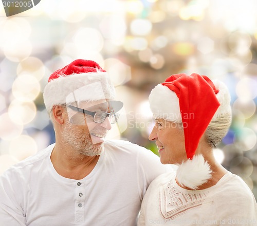 Image of happy senior couple in santa helper hats