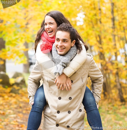 Image of smiling friends having fun in autumn park