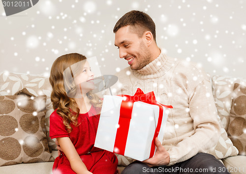 Image of smiling father and daughter holding gift box