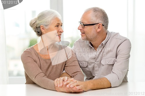 Image of happy senior couple sitting on sofa at home
