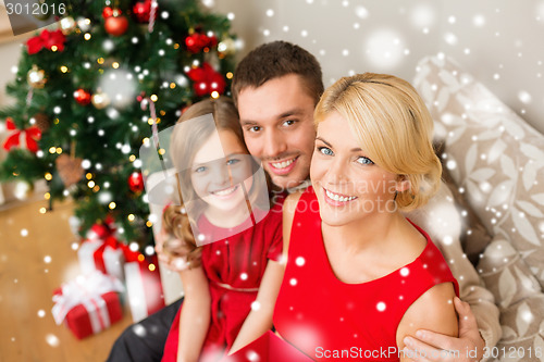 Image of smiling family holding gift box