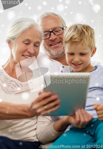 Image of smiling family with tablet pc at home