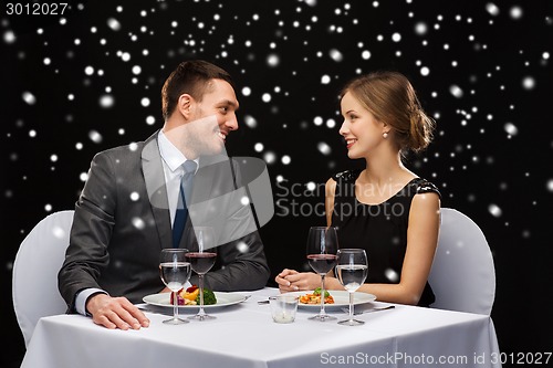 Image of smiling couple eating main course at restaurant