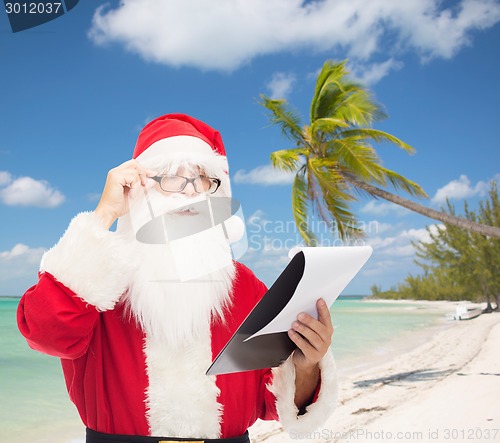 Image of man in costume of santa claus with notepad