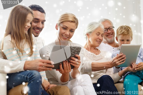 Image of smiling family with tablet pc computers at home