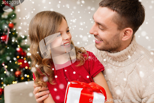 Image of smiling father and daughter holding gift box
