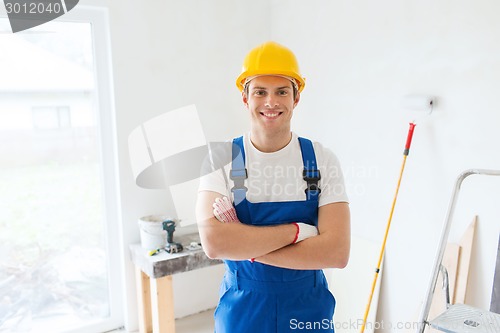 Image of smiling young builder in hardhat  indoors