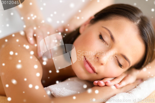 Image of beautiful young woman in spa salon getting massage