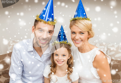 Image of smiling family in party hats at home