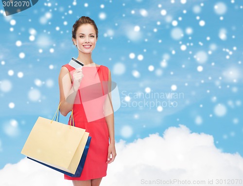 Image of smiling woman with shopping bags and plastic card