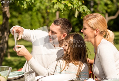 Image of happy family with tablet pc outdoors