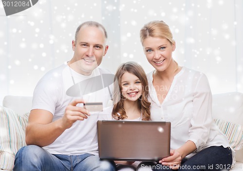 Image of happy family with laptop computer and credit card