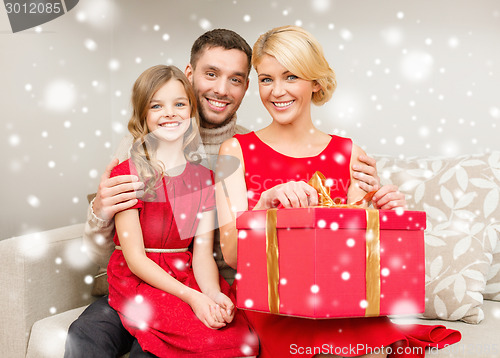 Image of smiling family holding gift box