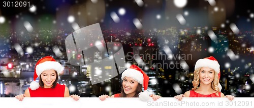 Image of women in santa helper hat with blank white board