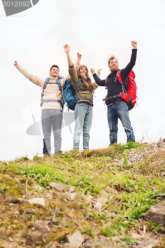 Image of group of smiling friends with backpacks hiking