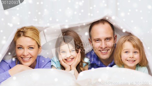 Image of happy family with two kids under blanket at home