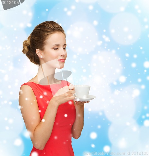 Image of smiling woman in red dress with cup of coffee