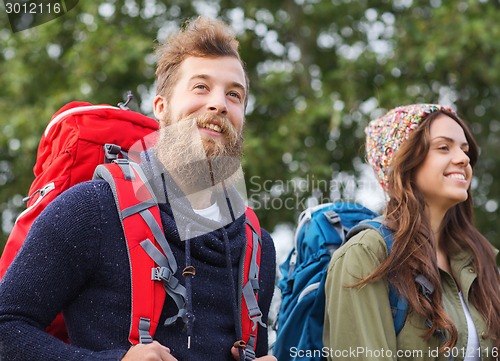 Image of group of smiling friends with backpacks hiking