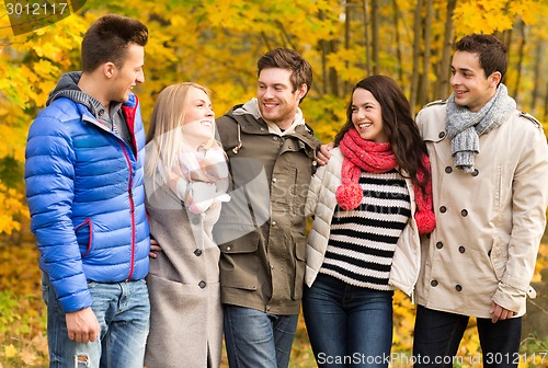 Image of group of smiling men and women in autumn park