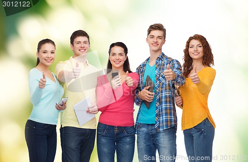 Image of group of teenagers with smartphones and tablet pc