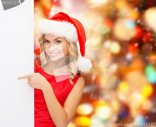 Image of smiling young woman in santa hat with white board