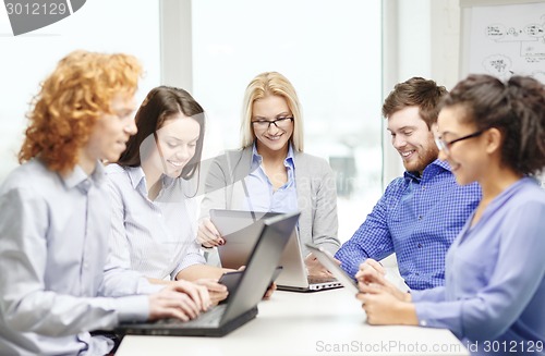 Image of smiling team with laptop and table pc computers