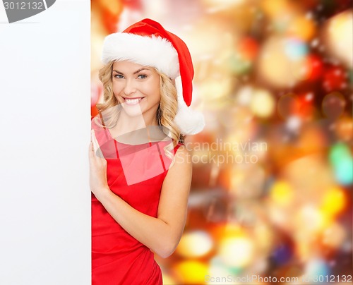 Image of smiling young woman in santa hat with white board