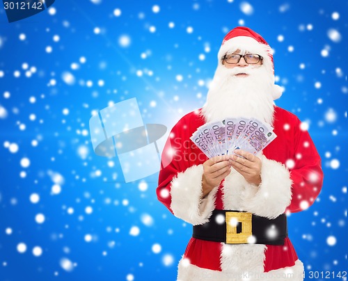 Image of man in costume of santa claus with euro money