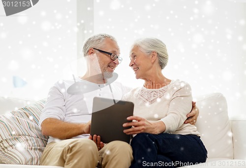 Image of happy senior couple with tablet pc at home