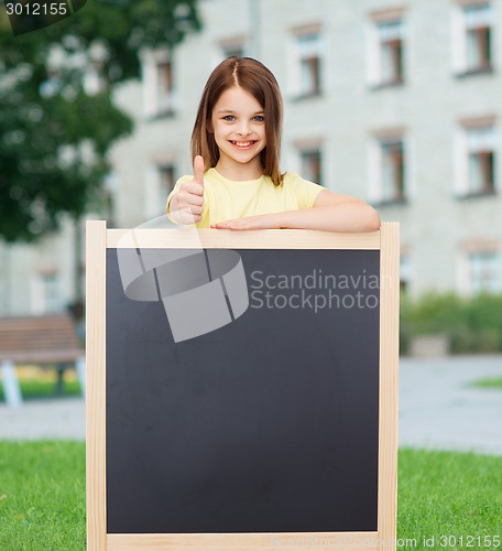 Image of happy little girl with blank blackboard