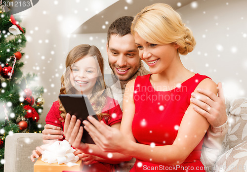 Image of smiling family with tablet pc at home