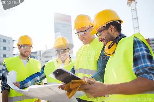 Image of group of builders with tablet pc and blueprint