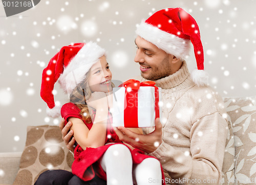 Image of smiling father and daughter holding gift box