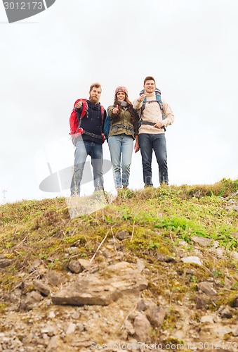 Image of group of smiling friends with backpacks hiking