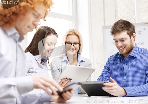 Image of smiling team with table pc and papers working